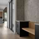 Concrete walls meet sleek cabinetry in this designer drop zone combining style and utility to keep life organized and flowing with ease from indoors to out.