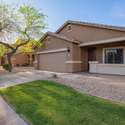 Green grass and rock landscaping bring balanced beauty to the front yard. With north/south orientation and shaded patio features, the home is designed for comfort in the Arizona heat.