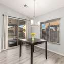 The dining space is bathed in light from the large windows and sliding glass door that leads to a private backyard. Easy access to outdoor entertaining makes this space perfect for hosting or casual dining.