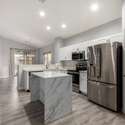 A standout feature of the home, this kitchen offers a marble-look island, stainless steel appliances, and bright white cabinetry. It blends modern design with everyday functionality in a space made to impress.
