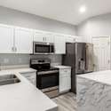 Function meets form in this corner of the kitchen, where you'll find clean white quartz surfaces, a deep stainless sink, and an upgraded faucet. The light, bright finishes offer a timeless aesthetic.