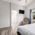 The primary bedroom is filled with natural light and features tall ceilings, soft neutral tones, and sleek flooring. This space offers a calm, quiet escape in a well-designed layout.
