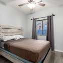 A well-proportioned guest bedroom offers rich-toned flooring, clean white trim, and a large window. It's move-in ready, ideal for guests, kids, or additional office space.