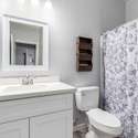 The hall bathroom is fresh and functional, featuring an upgraded vanity, framed mirror, and modern hardware. Perfect for guests or shared use, it delivers style and convenience in every detail.