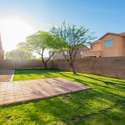The beautifully maintained backyard offers a generous grassy area, mature shade trees, and a paved patio pad ideal for grilling, dining, or hosting under open skies. A perfect outdoor escape in a quiet residential setting.