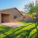 This expansive backyard view showcases a large covered patio, paver flooring extension, and lush lawn ideal for outdoor dining, weekend lounging, or future landscaping projects. A perfect blend of functionality and charm.