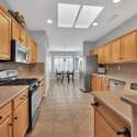 Highlighted by a gas range, stainless steel appliances, and rich wood cabinetry, this fully stocked kitchen is a dream for summer renters who love cooking at home in Surprise.