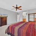This generously sized primary bedroom includes direct access to the en-suite bathroom, neutral colors, and plenty of space ideal for long or short-term rental guests.