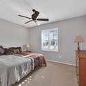 This secondary bedroom offers plush carpeting, large windows, and warm neutral tones perfect for visiting guests or a flexible work-from-home setup in your Surprise rental.