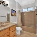 This updated hallway bathroom features a sleek solid-surface countertop, modern lighting, and a full tub-shower combo. An ideal setup for guests staying in this fully furnished Surprise rental.