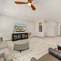 A serene retreat for everyday living, this room is highlighted by custom ceiling fan lighting, a neutral color palette, and large-format tile flooring. Watch the Arizona landscape unfold right from your sofa in this thoughtfully updated interior.