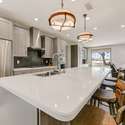 Gather around this oversized island that serves as a stylish anchor to the kitchen. With rich wood tones, overhead lighting, and built-in storage, this space is perfect for morning coffee, casual meals, or wine with friends.