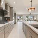 A modern cooking experience awaits with a stainless steel hood, gas cooktop, and polished tile backsplash. Whether hosting or meal-prepping, this setup is as functional as it is magazine-worthy.