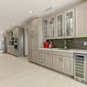 A stunning built-in cabinetry wall combines form and function with elegant glass-front cabinets, deep drawers, and a wine fridge below. Ideal for hosting in style or storing your favorite essentials in this upgraded Surprise home.