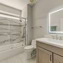 This updated guest bathroom features a quartz vanity, backlit LED mirror, and a designer tile tub/shower combo. Stylish and functional for everyday comfort.