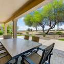 The covered travertine patio extends your living space with elegant finishes and shade from mature trees. Enjoy golf course views and alfresco dining year-round.