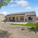 The home s back fa ade blends indoor-outdoor flow with large sliding doors and picture windows. Covered patio, upgraded pavers, and turf invite easy entertaining.