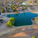 Aerial perspective reveals lush fairways and serene water features surrounding this Surprise property. The community layout provides a blend of natural beauty and neighborhood charm.