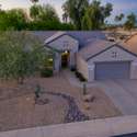 As the sun sets, this Surprise residence glows with warm desert tones and elegant exterior lighting. Its inviting presence is framed by native landscaping and tranquil surroundings.