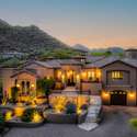 Set in Scottsdale s premier Hidden Hills community, this striking estate showcases its hillside placement, dramatic lighting, and private gated entry framed by native desert landscape and scenic mountain backdrops at sunset.