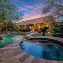 Step into your own Scottsdale resort with this lush backyard featuring a heated pool, raised spa, boulder accents, and string lights. Ideal for serene evenings, family fun, or outdoor entertaining in year-round sunshine.