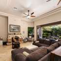 Experience open-concept comfort in this elegant living room, highlighted by large pocket sliders that frame the lush backyard. Tile floors, tray ceilings, and natural light create effortless Scottsdale-style indoor-outdoor living.