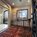 Display your wine collection in a climate-controlled entry wine room with custom ironwork and built-in shelving. This curated space adds luxury and character to the Scottsdale estate s entry experience.