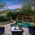A cozy fire pit anchors this backyard seating area with views of the Scottsdale mountains. Enhanced by poolside lighting and landscape design, it s a perfect setting for intimate nights outdoors.