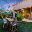 Dine outdoors under the canopy of mature trees in this peaceful backyard space. The extended patio and large dining table make this Scottsdale home perfect for entertaining with ease.