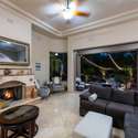 A cozy fireplace anchors the living space, while retractable sliders invite you into the illuminated backyard oasis. Indoor-outdoor living at its best in Scottsdale.