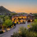 This Scottsdale estate makes a bold statement with its elevated position against the backdrop of rugged mountains and soft sunset skies. Surrounded by mature desert flora and enhanced with architectural lighting, the home's striking curb appeal and multi-level design offer a warm welcome to refined desert living.