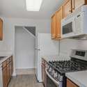 Kitchen with a view of the foyer hall and stairs leading to the loft space.