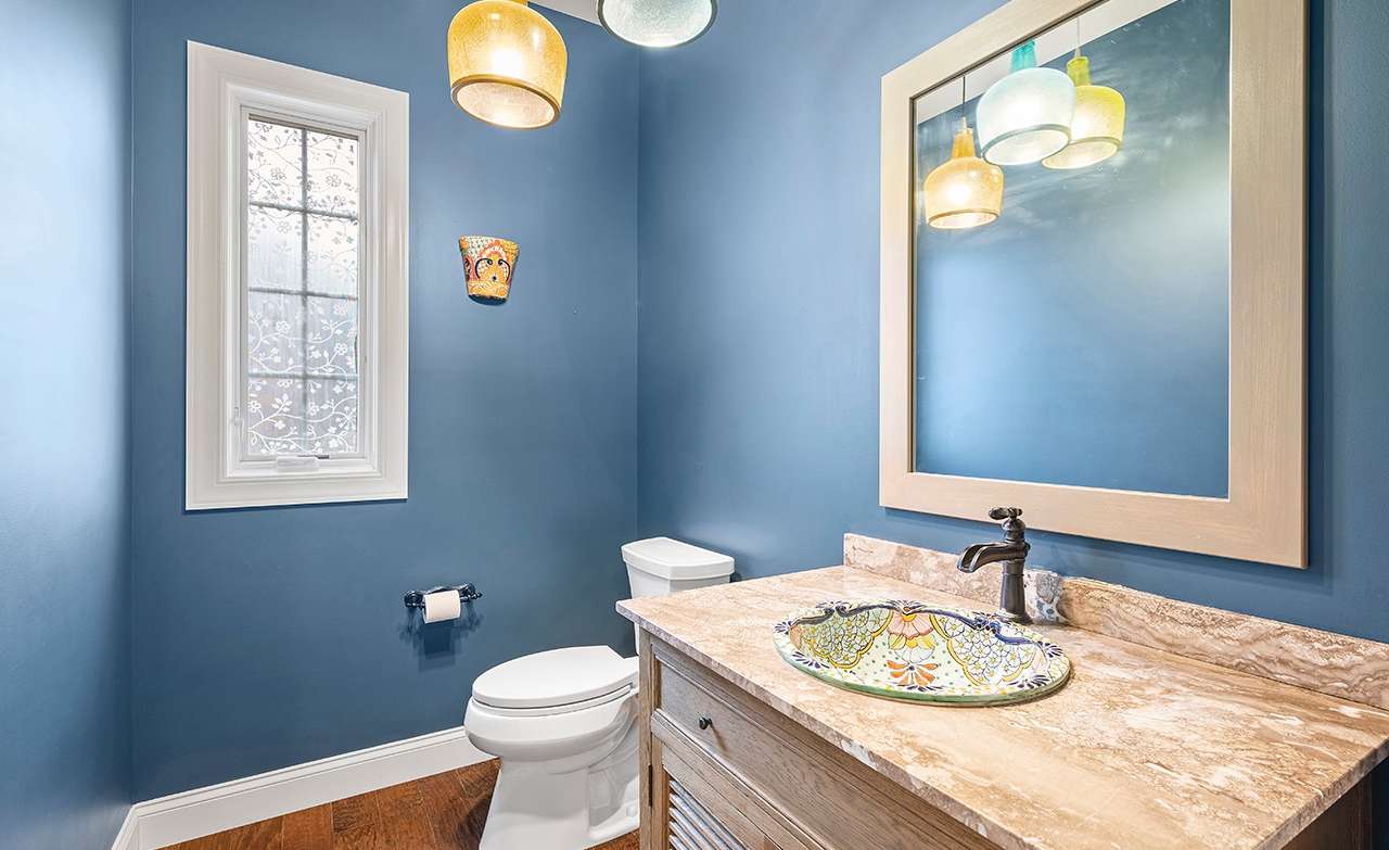 25 of 69. The powder room is highlighted by a custom hand-painted sink.