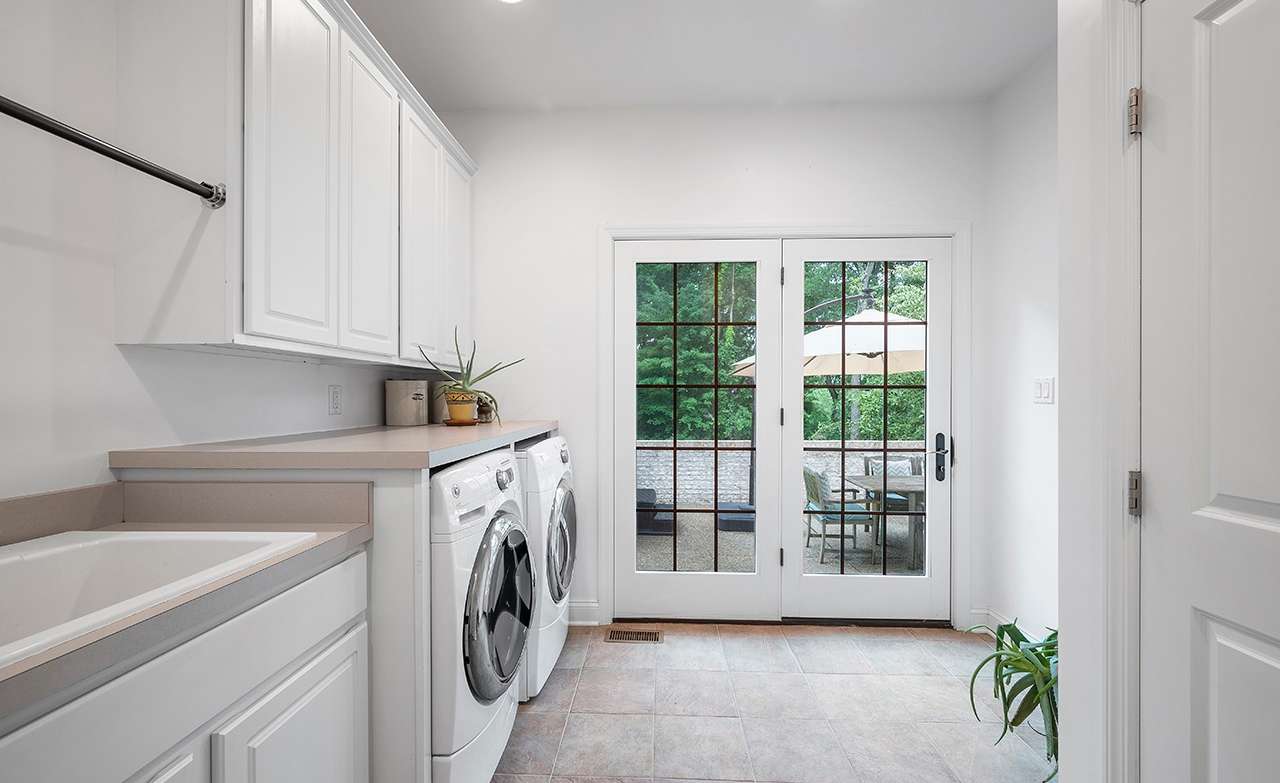 27 of 69. The brightly-lit laundry room is complemented by lots of storage, a basin sink, a built-in dog shower and access to the patio.