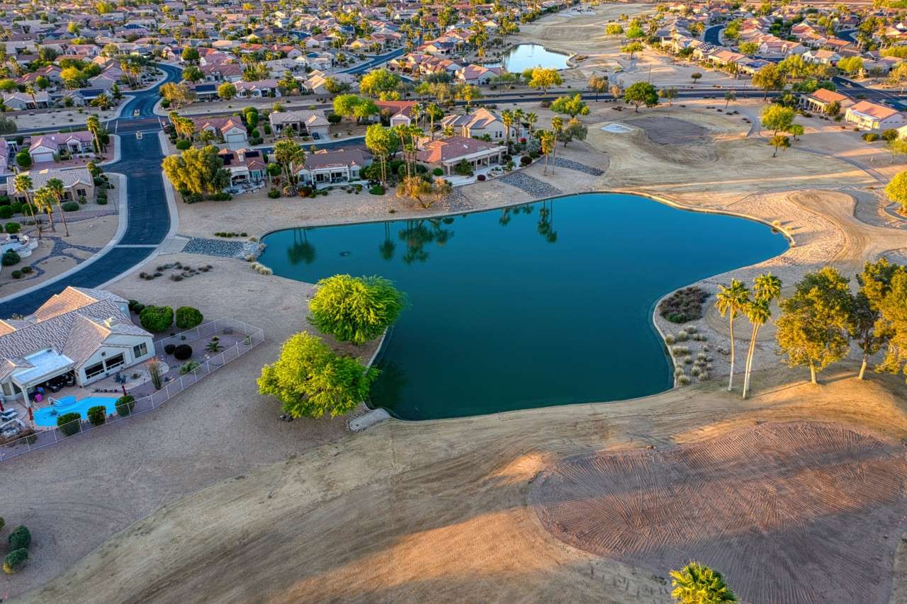 33 of 35. Aerial perspective reveals lush fairways and serene water features surrounding this Surprise property. The community layout provides a blend of natural beauty and neighborhood charm.