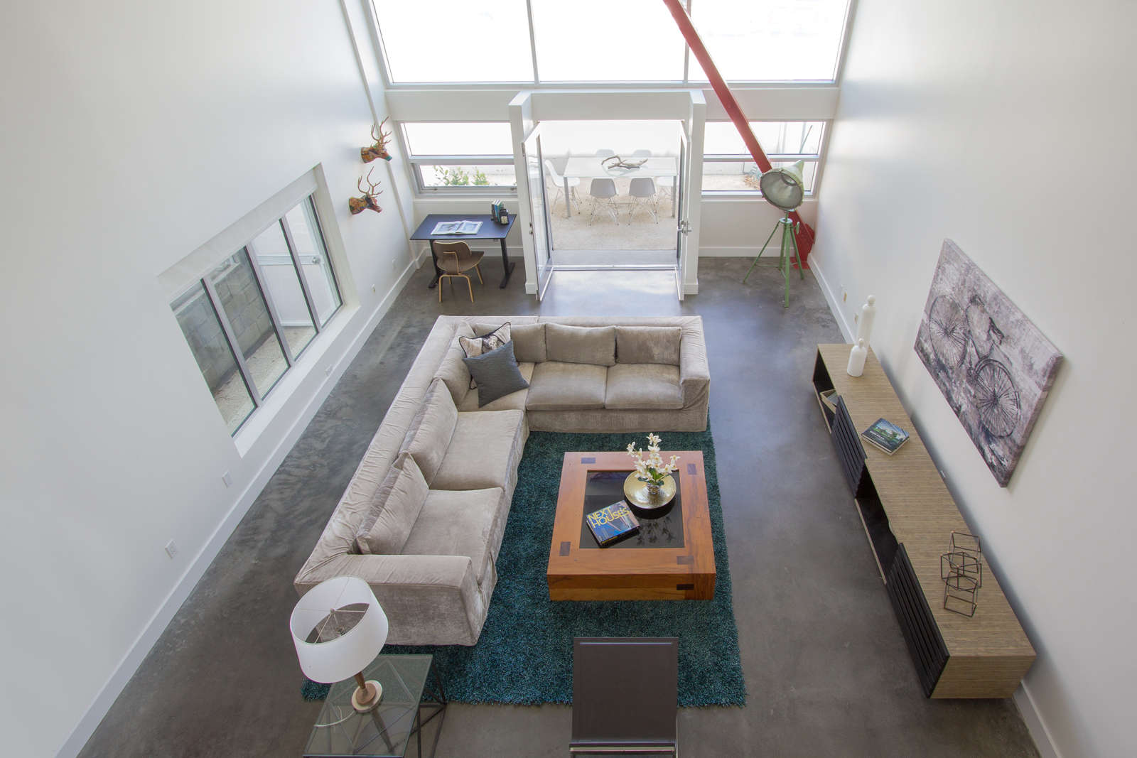 6 of 27. High ceilings looking down from loft mezzanine to downstairs living area.