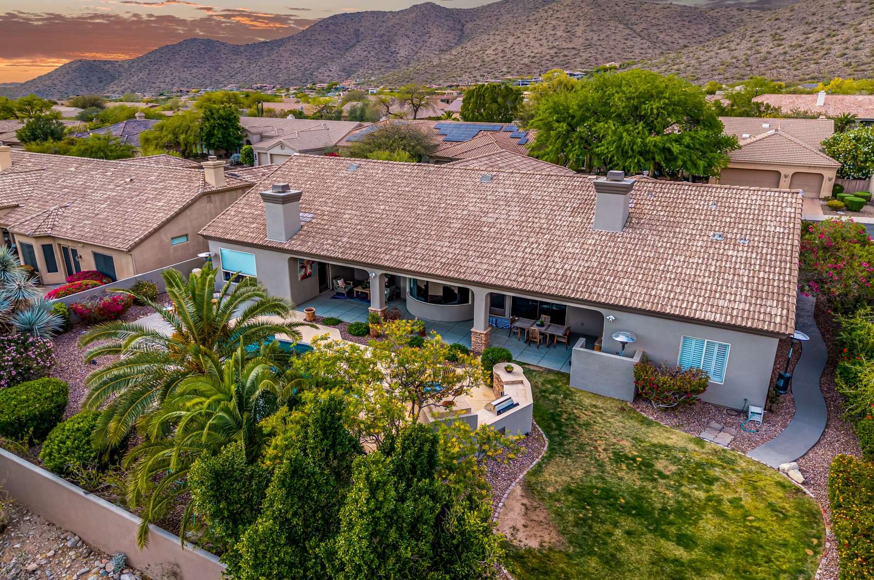 65 of 65. This elevated view captures a beautifully maintained backyard featuring a sparkling pool, shaded patio, and built-in BBQ, all set against striking mountain scenery. Located in one of Arizona s premier neighborhoods, this home offers a seamless blend of luxury amenities, energy-efficient design, and tranquil outdoor spaces perfect for year-round enjoyment.