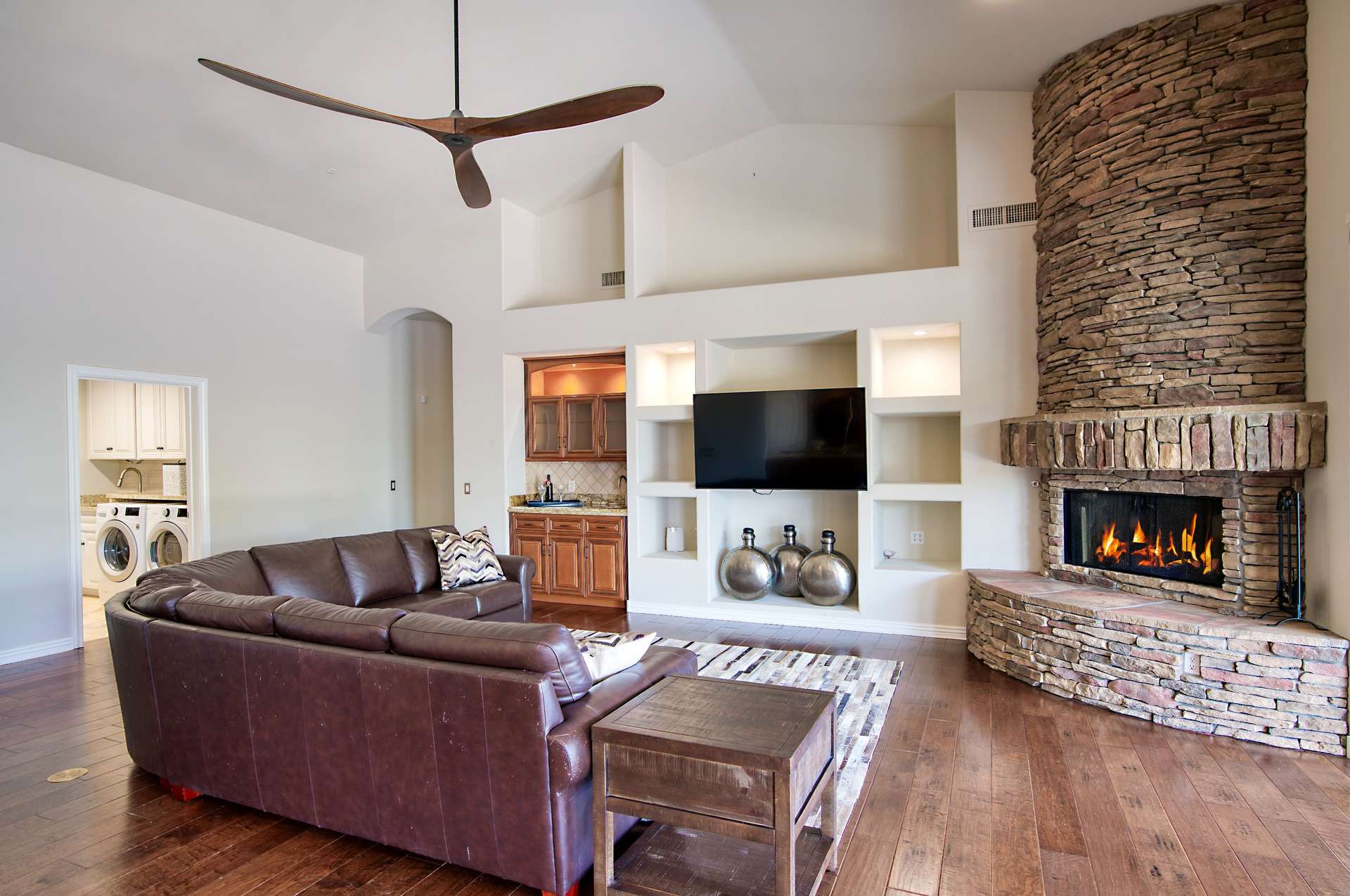 11 of 65. Warm up by the striking stone fireplace in this inviting great room featuring built-in media shelving and a sleek wet bar. Ideal for cozy evenings or entertaining in your North Scottsdale retreat.
