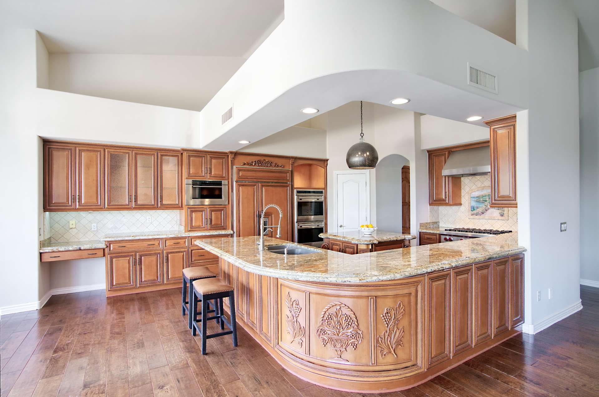 12 of 65. This chef-inspired kitchen offers a grand curved island with seating, granite countertops, and custom cabinetry. Enjoy high-end finishes and ample prep space for hosting or everyday living.