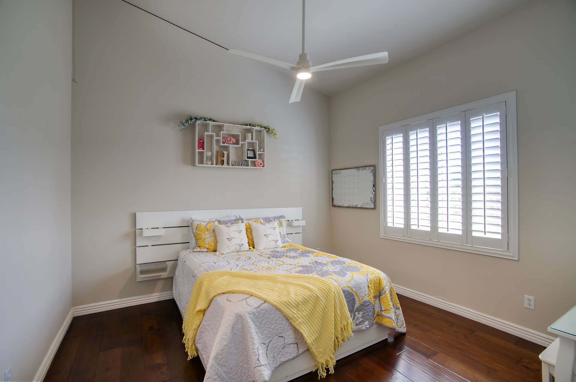 21 of 65. A warm and inviting guest room featuring plantation shutters, vaulted ceilings, and wood floors ideal for peaceful rest or a private reading space.