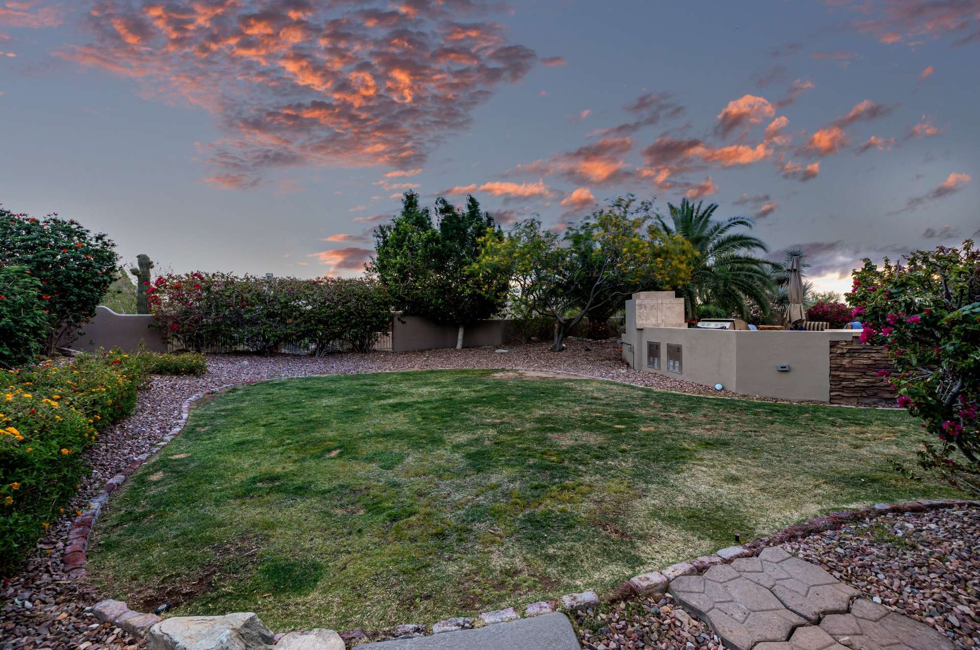 30 of 65. Surrounded by mature landscaping and evening skies, this backyard is a peaceful haven featuring a built-in grill and entertaining-ready green space.