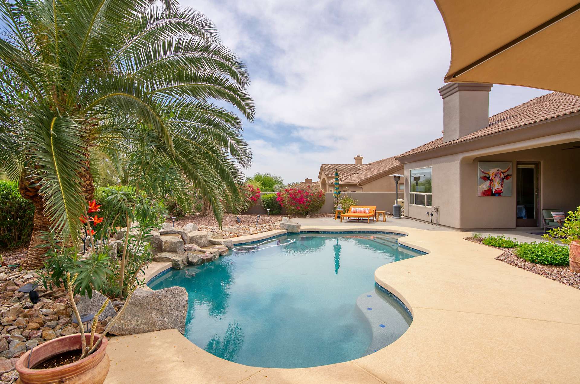 31 of 65. Discover a serene backyard setting with lush green space, mature trees, and privacy landscaping. This versatile outdoor area is ideal for family fun, pets, or future customization in sunny Arizona.