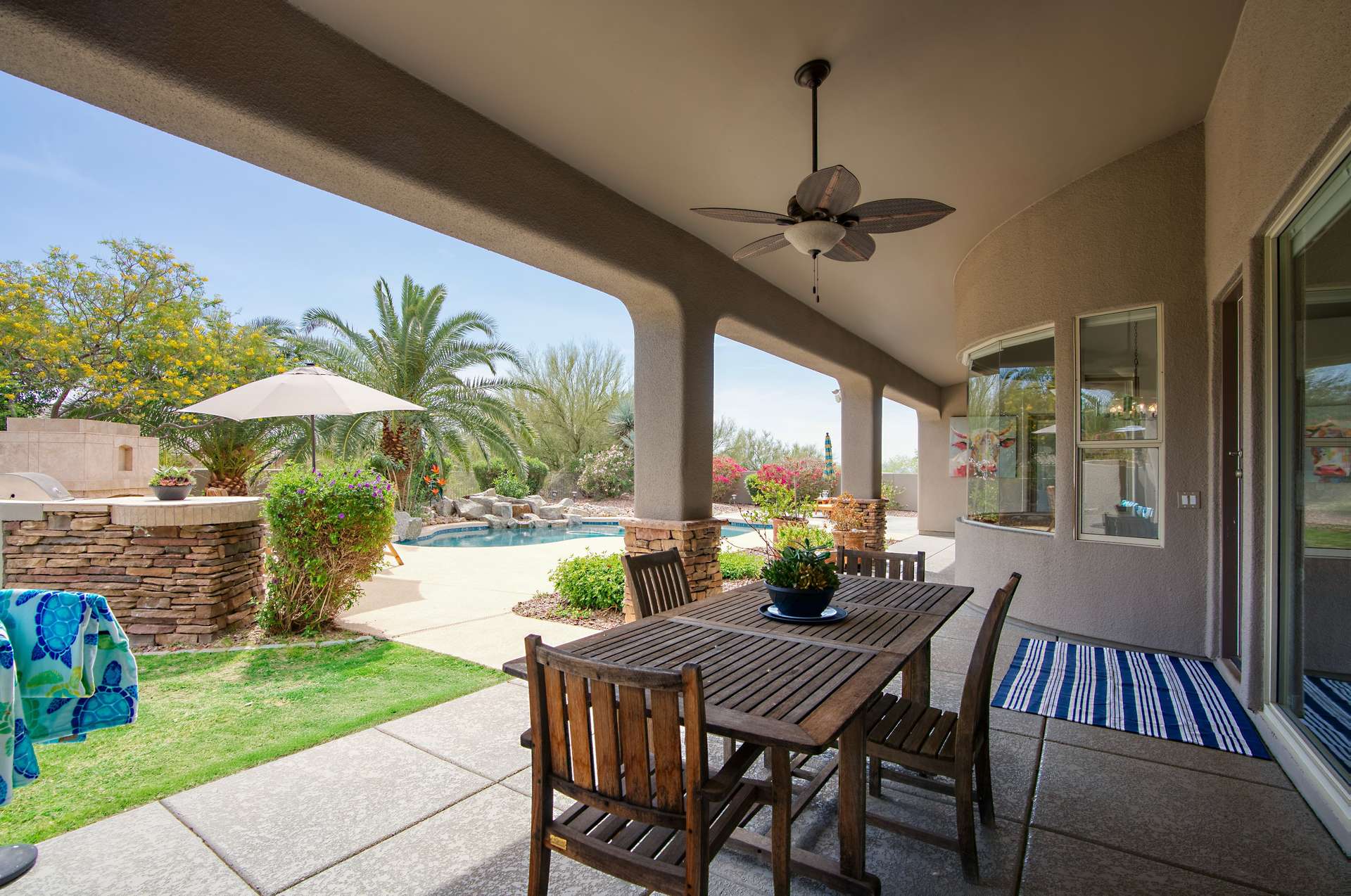 32 of 65. Dine outdoors year-round beneath this elegant covered patio featuring overhead fans, archways, and views of the landscaped backyard. A seamless connection to the home s interior makes entertaining effortless.