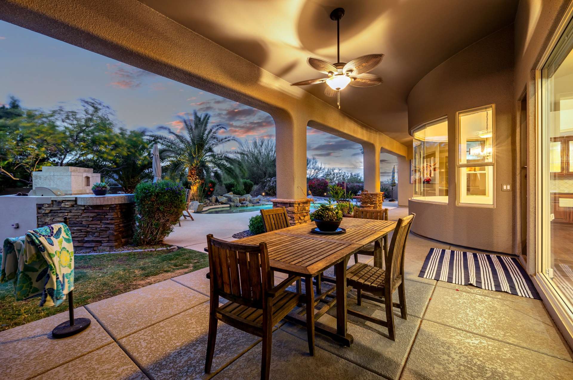 33 of 65. As the sun sets, this covered outdoor dining area becomes a warm and inviting gathering place. With stone accents, ceiling fans, and access to the yard and interior, it s built for stylish hosting.