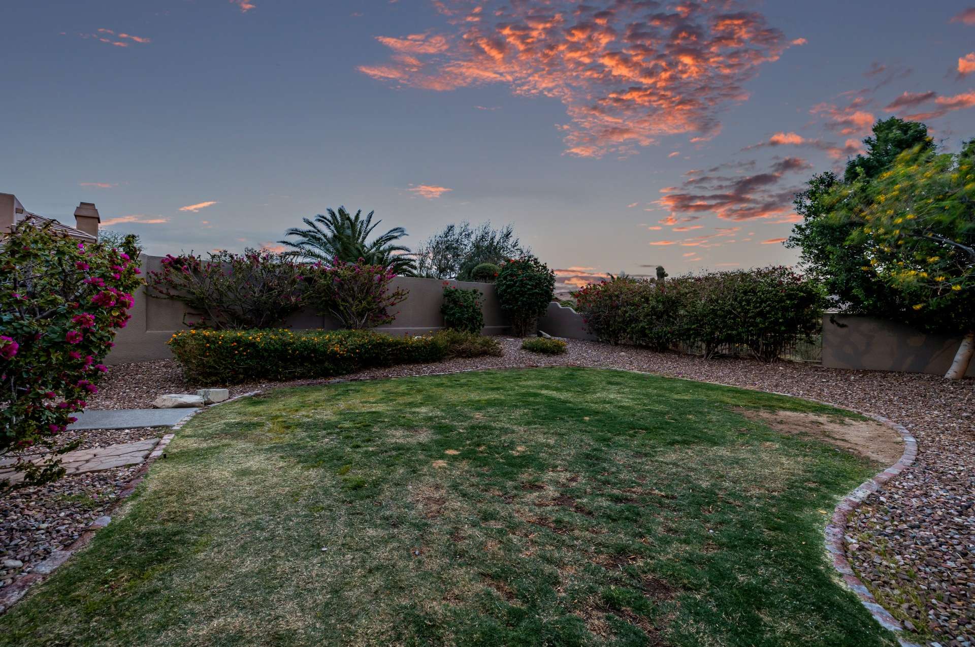 47 of 65. This private yard blends a soft green lawn with low-maintenance desert landscape, offering a peaceful balance of usable space and natural beauty. Enjoy tranquil moments in a yard designed for both serenity and play.