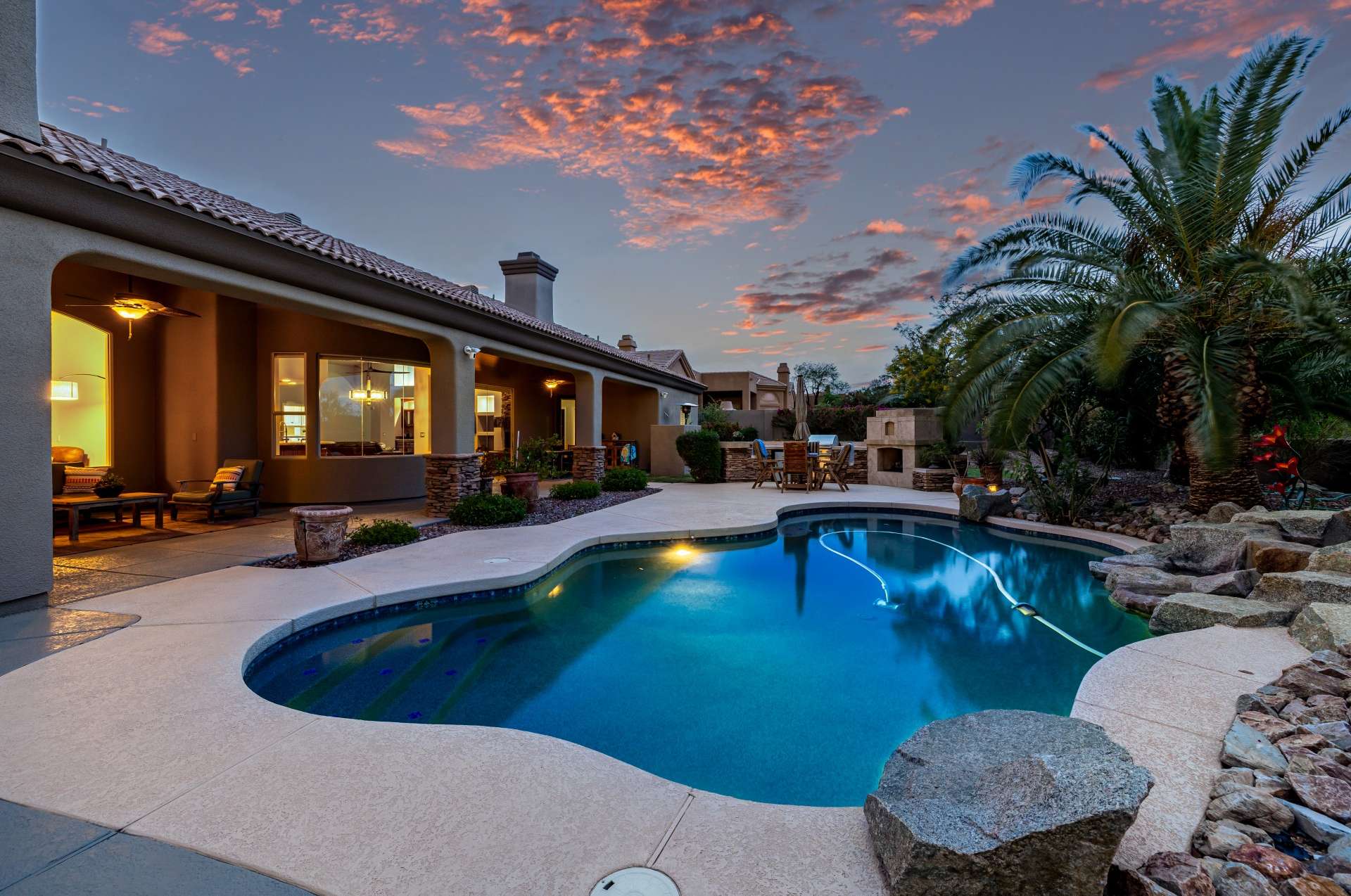 50 of 65. Soak in the luxury of your private resort-style pool as the desert sky glows with rich sunset colors. This inviting backyard in Scottsdale offers seamless indoor-outdoor living with a spacious covered patio and lush landscaping that wraps around the sparkling water feature.