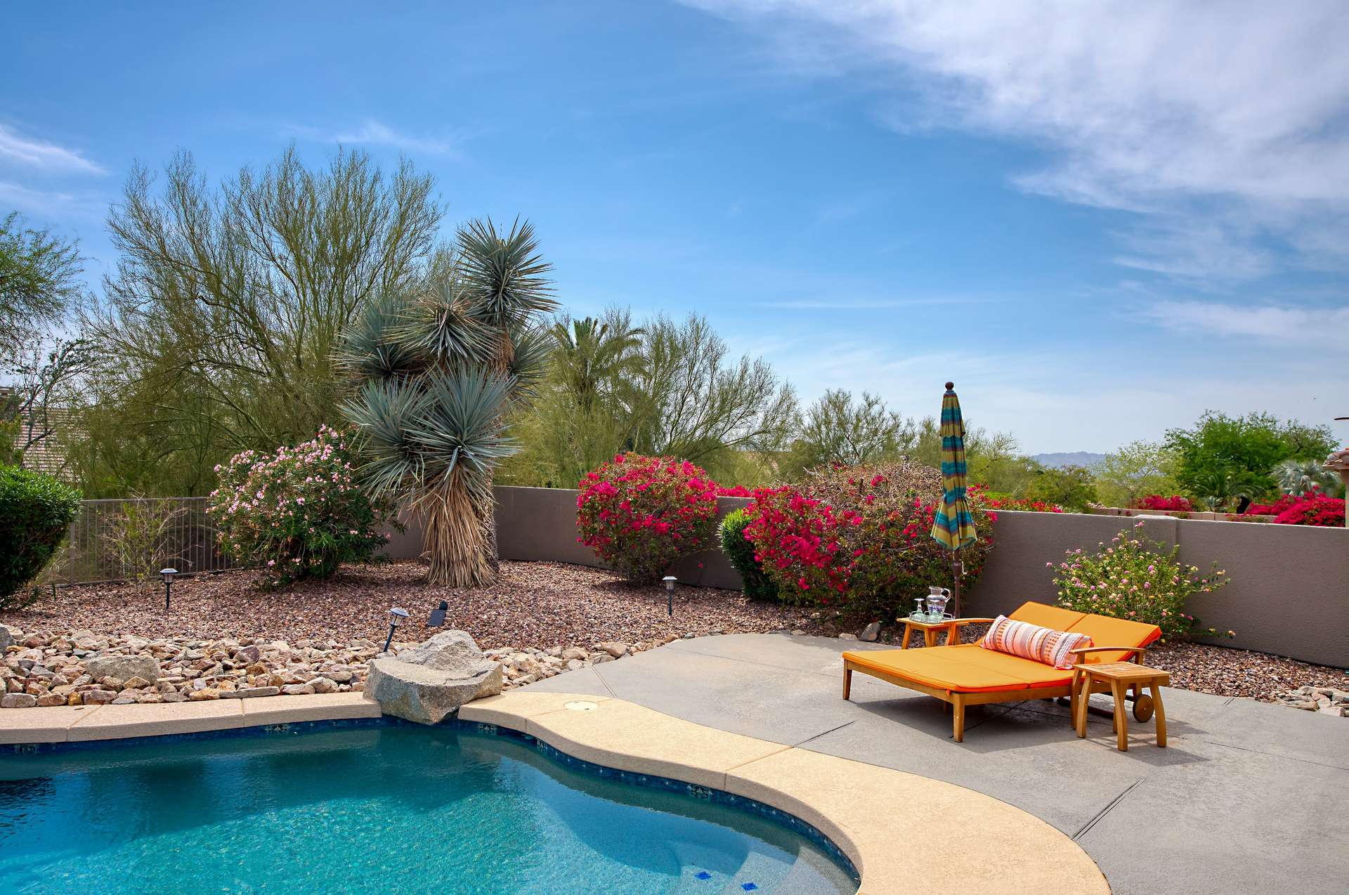 52 of 65. This tranquil lounge area is ideal for sunbathing or sipping cocktails poolside. Surrounded by desert greenery, the curved pool deck offers privacy and beauty, making it the perfect place to enjoy outdoor living in the heart of Scottsdale.