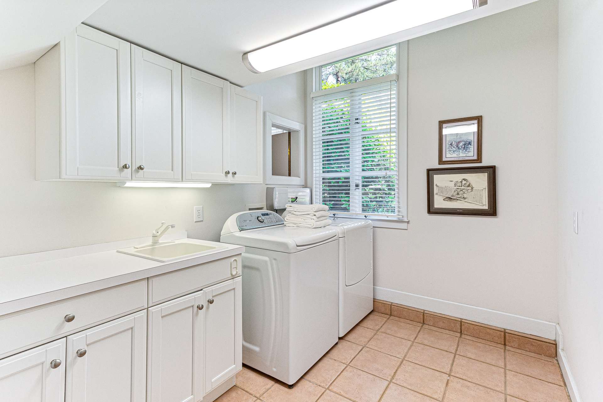 56 of 66. Laundry room with utility sink off garage. Washer and dryer convey.