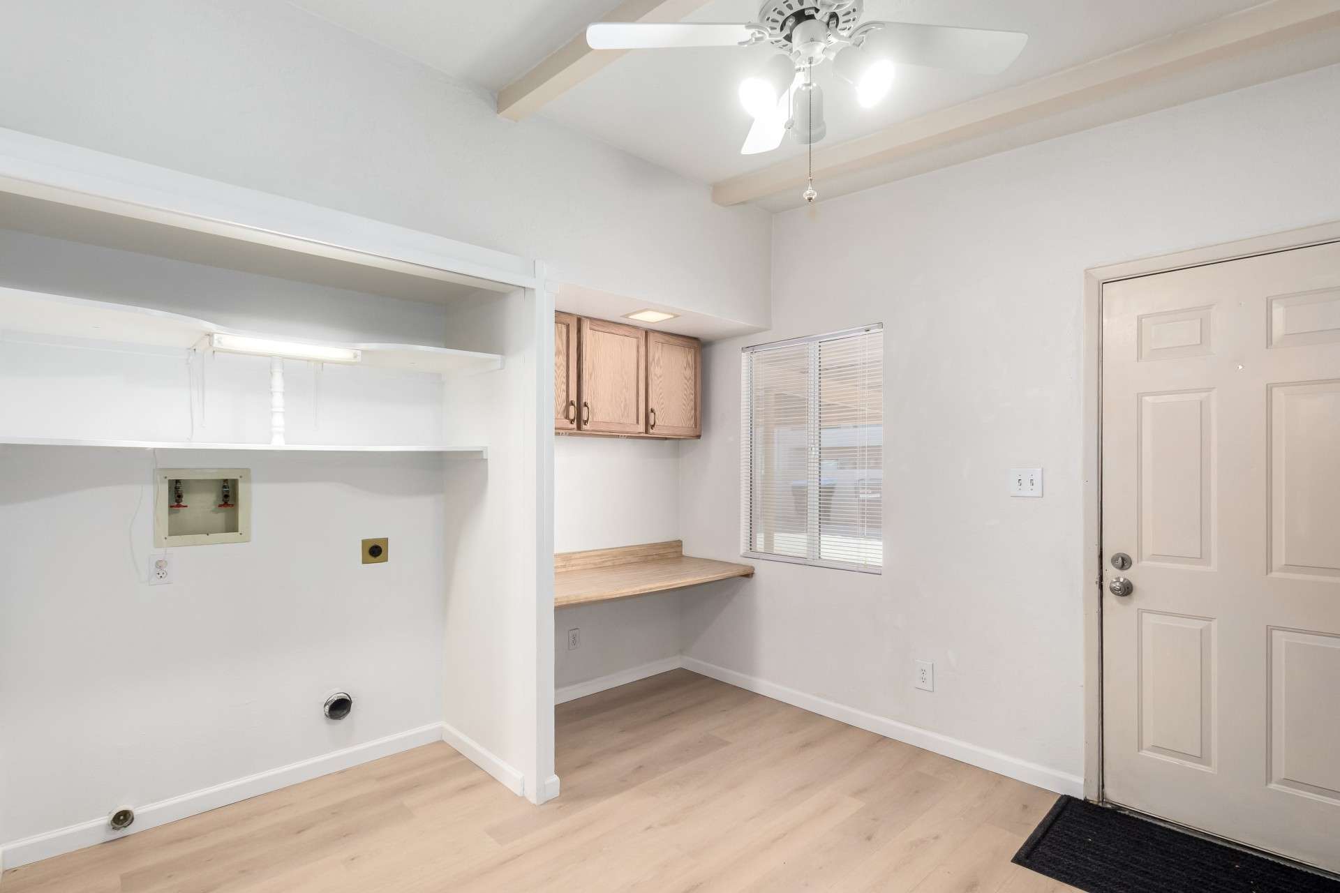 22 of 26. This functional space offers an in-unit laundry hookup along with a built-in desk and shelving, ideal for home organization or remote work. Natural light fills the area, making it a perfect mix of convenience and efficiency in this Phoenix condo.