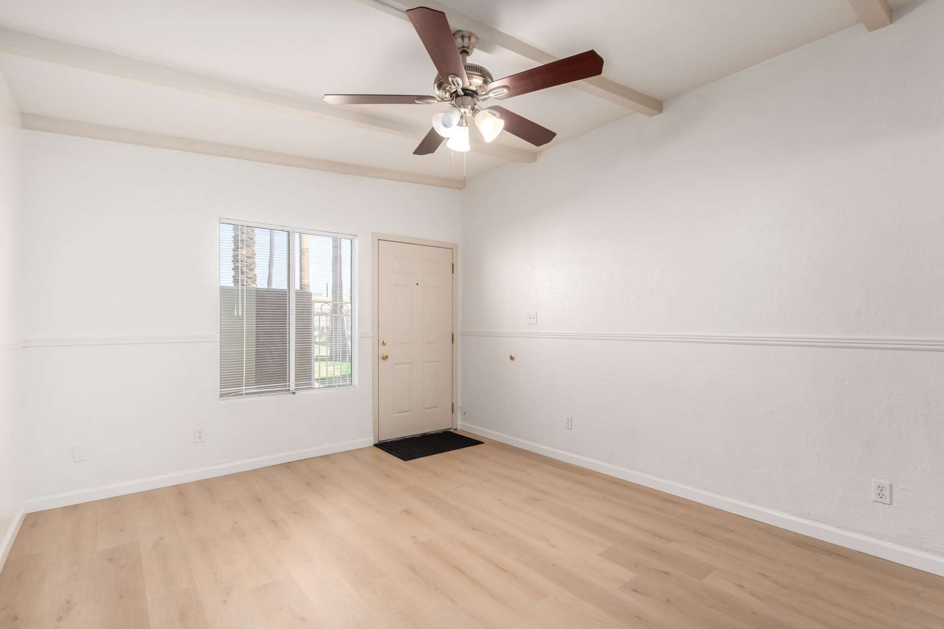 10 of 26. Featuring large windows, neutral color tones, and a sleek ceiling fan, this living room is a bright and inviting space. The open layout provides endless design possibilities while ensuring comfort and functionality.